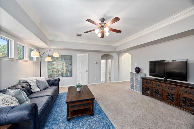 Massive gameroom with tray ceilings and crown molding offers beautiful transom windows filled with natural light. | Image 34
