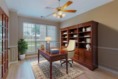 Office or dining room area with light hardwood / wood-style floors, ceiling fan, and crown molding photo was virtual staged. | Image 1