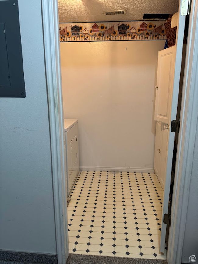 Bathroom featuring electric panel, baseboards, washer and clothes dryer, and tile patterned floors | Image 15