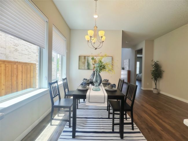 Dining room with a chandelier, wood finished floors, and baseboards | Image 8