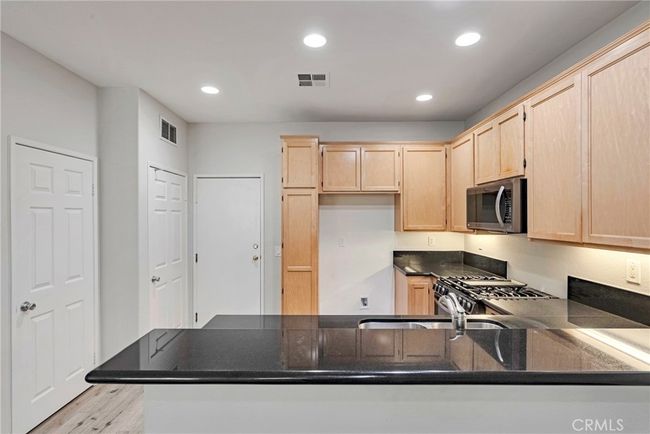KITCHEN WITH STAINLESS APPLIANCES, BREAKFAST BAR AND PANTRY | Image 17