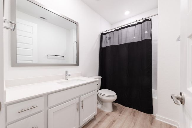 Bathroom featuring vanity, wood finished floors, visible vents, toilet, and shower / tub combo with curtain | Image 24