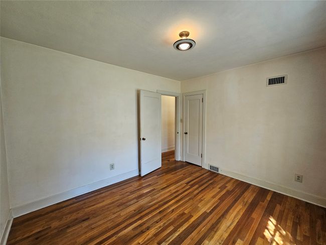 Spare room featuring dark wood-style floors, visible vents, and baseboards | Image 15