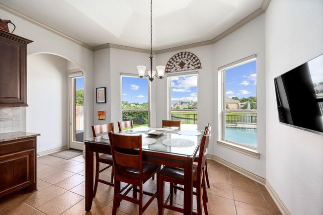 The breakfast area sits just off the kitchen and offers views of the pool and lake behind the home. | Image 18