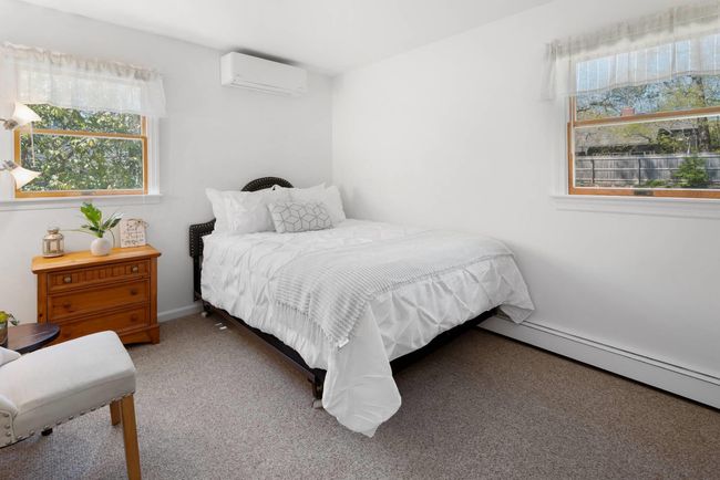 Bedroom with a wall mounted AC and carpet floors | Image 14