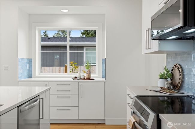 Another view taking in that bonus counter and cabinet area with the beautiful tile backsplash. | Image 14