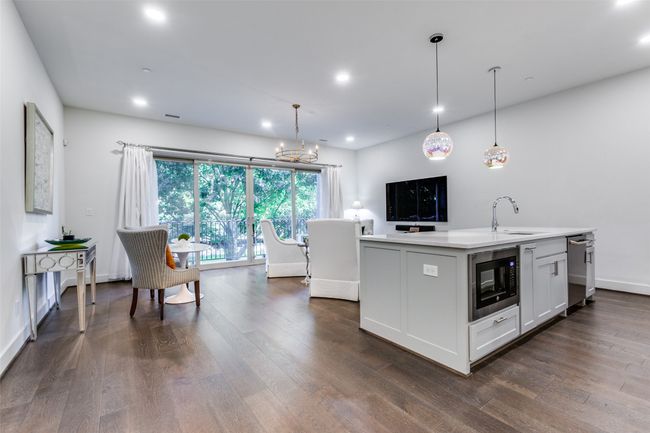 The wonderful open floorplan makes this unit so spacious and it flows perfectly for entertaining! Stainless microwave and dishwasher. The wood type floors are magnificent! | Image 6