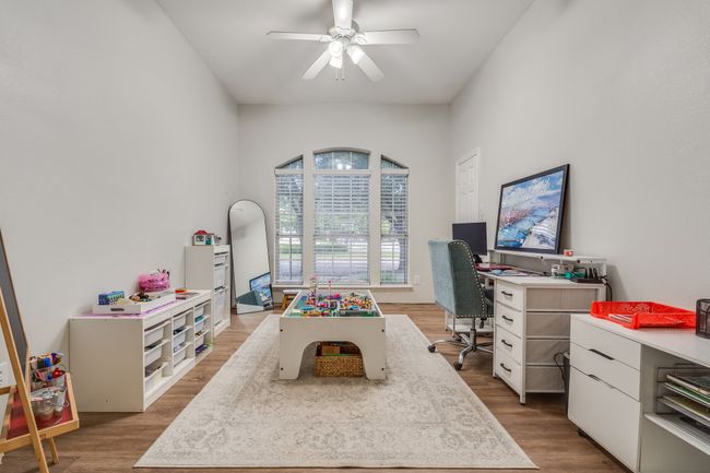 Game room featuring wood finished floors, a ceiling fan, and an office area | Image 8