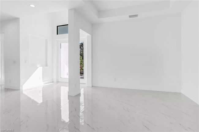 Tiled spare room with a tray ceiling | Image 7