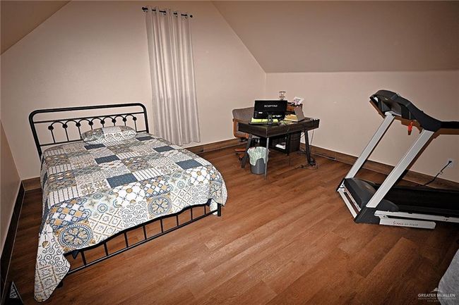 Bedroom with lofted ceiling and hardwood / wood-style floors | Image 15