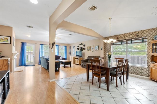 Dining room featuring a chandelier, light wood-style floors, lofted ceiling, and baseboards | Image 14