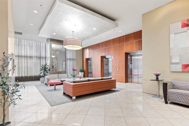 The space is designed with a blend of elegance and comfort, featuring high ceilings and expansive windows that flood the area with natural light, creating a bright and welcoming atmosphere. | Image 36