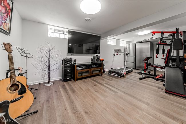 Exercise area with plenty of natural light, baseboards, and wood finished floors | Image 33