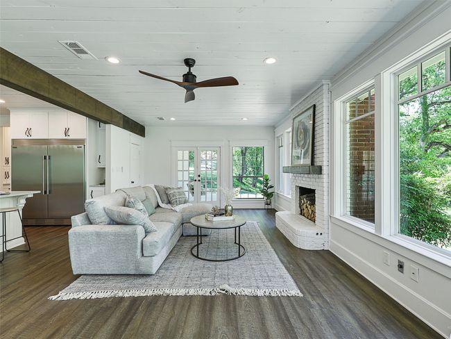 Living area featuring ceiling fan, a wealth of natural light, dark wood-style flooring, and visible vents | Image 17