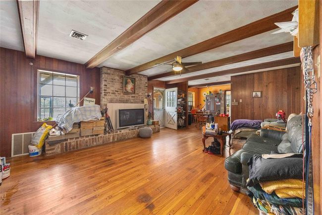 There is a wood log fireplace and hearth. | Image 12