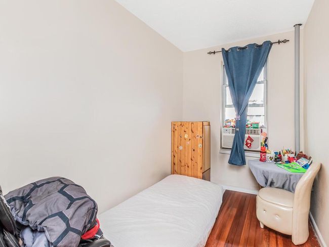 Bedroom featuring vaulted ceiling, wood finished floors, and baseboards | Image 7