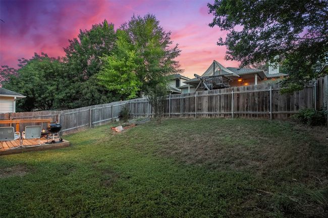 Relax on the covered back patio or deck offering the perfect spot to watch the sunset in your private, fenced in yard. | Image 35