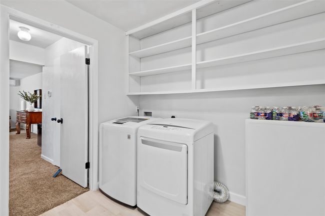Laundry room with light wood-style floors, laundry area, baseboards, and washing machine and clothes dryer | Image 15