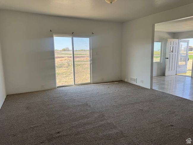 Empty room with a wealth of natural light, carpet flooring, and visible vents | Image 29