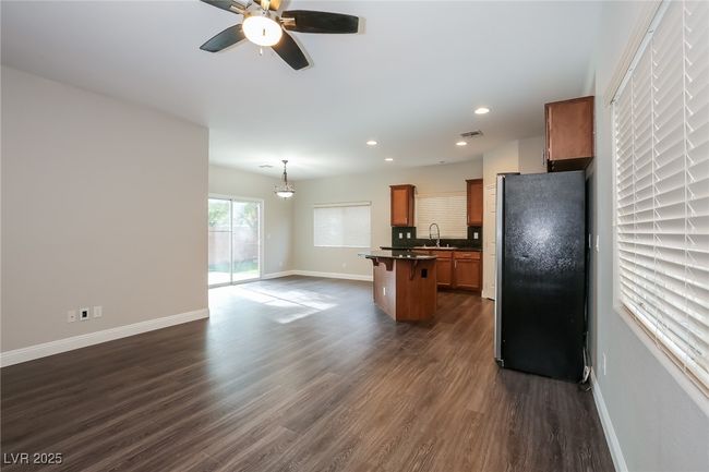 Kitchen with a center island, dark countertops, freestanding refrigerator, and baseboards | Image 4