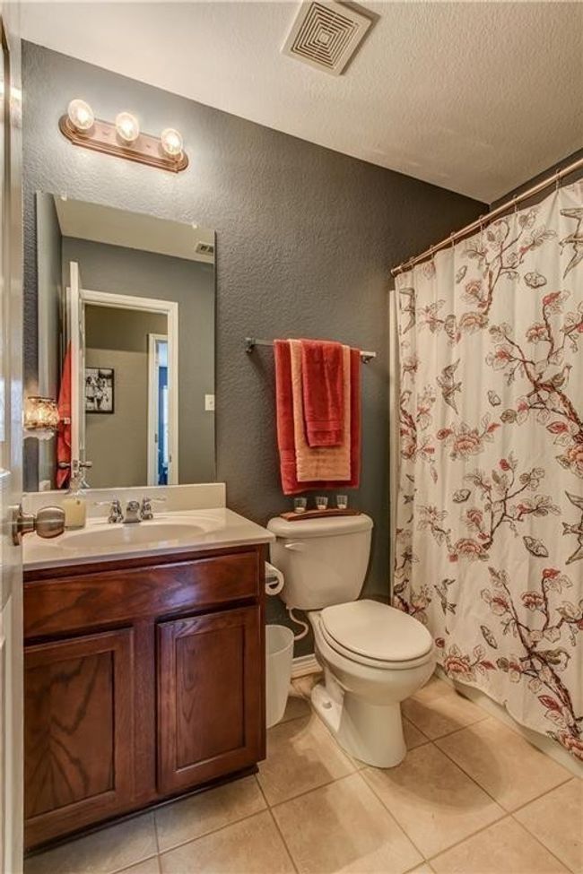 Bathroom featuring a textured wall, vanity, a textured ceiling, tile patterned flooring, and curtained shower | Image 11