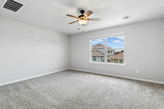 Carpeted spare room featuring a ceiling fan and baseboards | Image 23