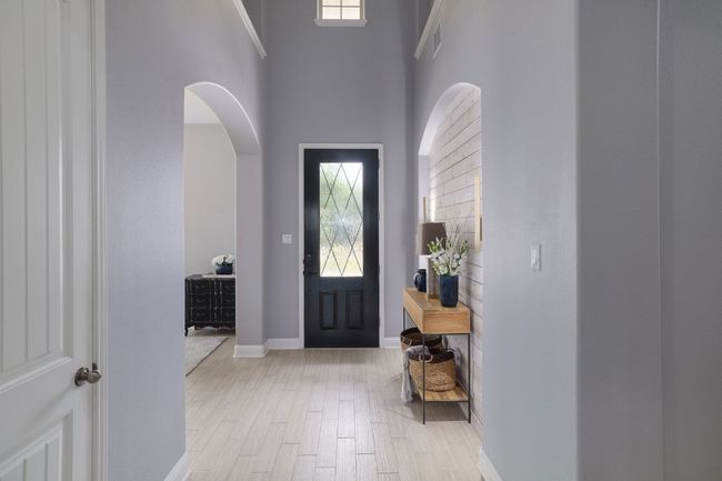 Foyer with arched walkways, baseboards, a towering ceiling, and light wood-type flooring | Image 14
