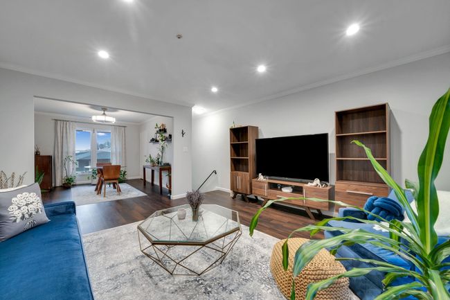 Living area with wood finished floors, ornamental molding, and recessed lighting | Image 10
