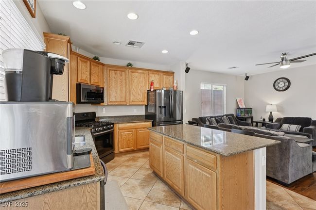 Kitchen featuring appliances with stainless steel finishes, open floor plan, a center island, recessed lighting, and a ceiling fan | Image 30