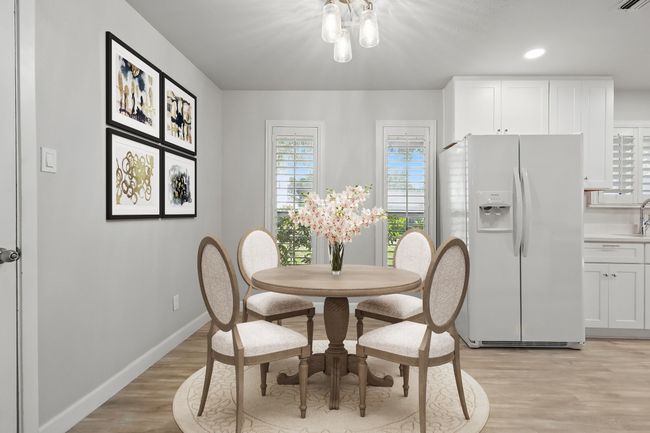 Dining area featuring light wood-style floors, a chandelier, baseboards, and recessed lighting | Image 11