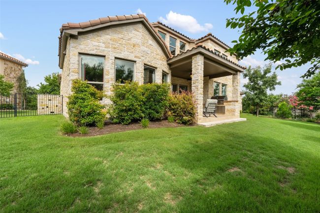 Back of property with stone siding, a patio, and a tile roof | Image 34