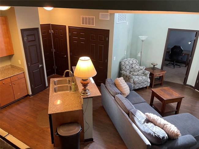 Living room with dark wood-style floors and a desk | Image 4