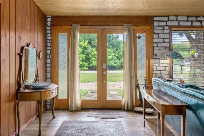 Doorway with french doors, wooden walls, light wood-style flooring, and wood ceiling | Image 4