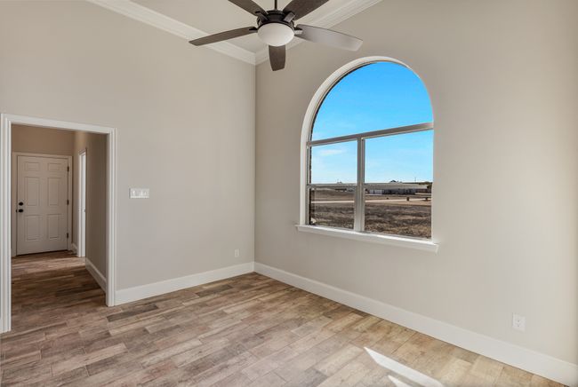 Unfurnished room with crown molding, baseboards, ceiling fan, and wood finished floors | Image 9