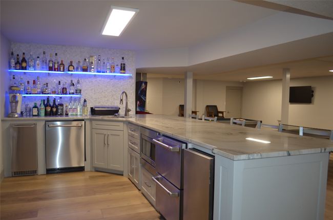 Indoor wet bar featuring stainless steel appliances and light wood-style floors | Image 28
