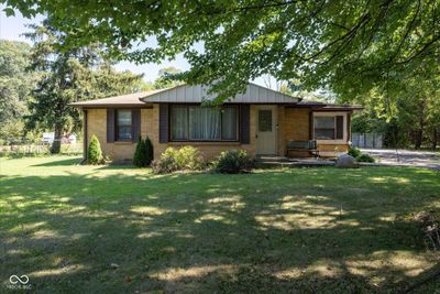 This efficient brick home sits back from the road and offers both a flexible floorplan and flexible outdoor space with multiple garages. | Image 1