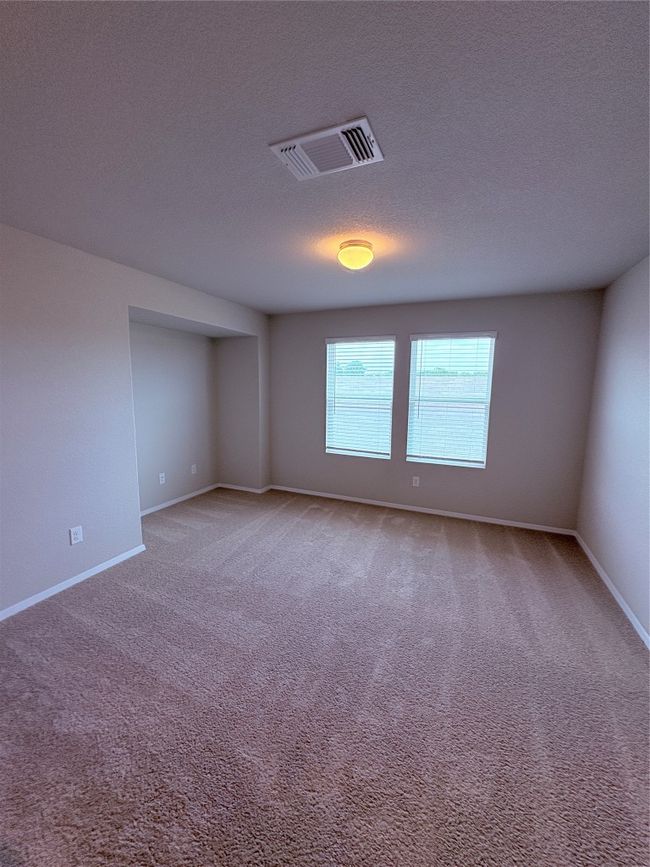Carpeted empty room with baseboards, a textured ceiling, and visible vents | Image 16