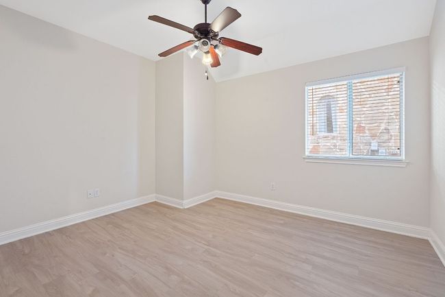 Unfurnished room featuring a ceiling fan, lofted ceiling, baseboards, and light wood finished floors | Image 33
