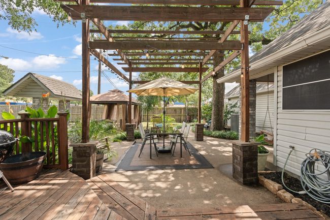 Fenced backyard featuring a gazebo, a pergola, outdoor dining space, and a wooden deck | Image 24