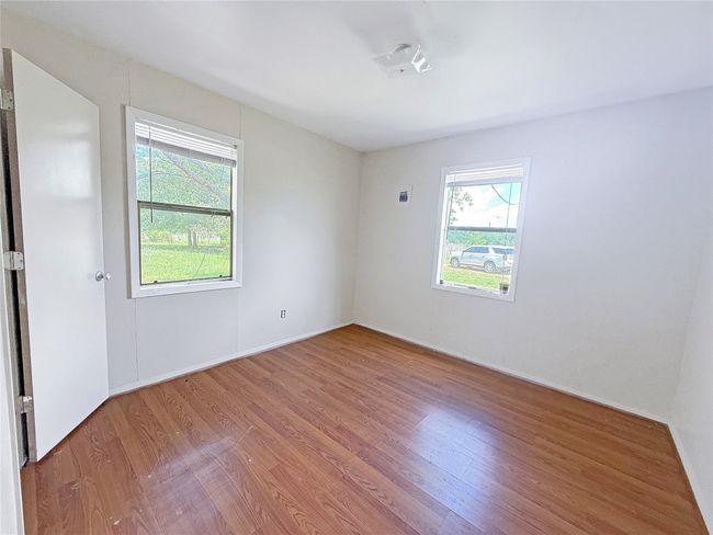 Empty room with baseboards, wood finished floors, and plenty of natural light | Image 11