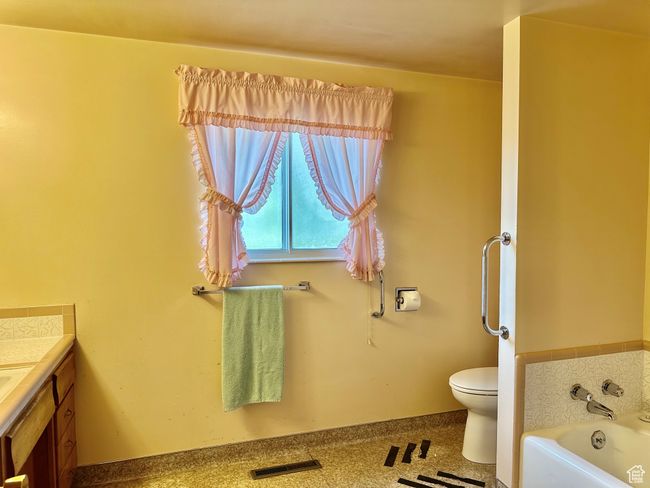 Large bathroom featuring vanity, tub and toilet | Image 11