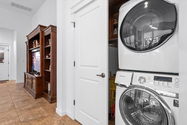 Laundry room featuring baseboards, visible vents, stacked washer / dryer, and laundry area | Image 29