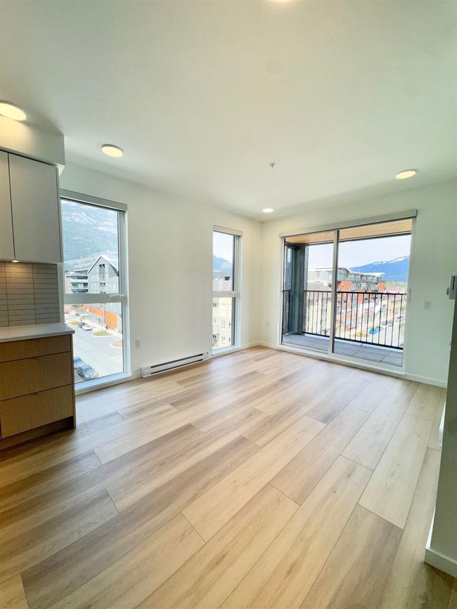Unfurnished living room with a healthy amount of sunlight, recessed lighting, baseboard heating, and light wood-style floors | Image 5