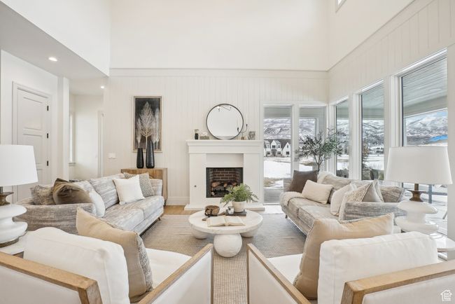 Living room with a fireplace, a high ceiling, and wood finished floors | Image 5