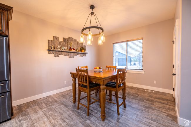 Dining area featuring dark wood finished floors and a chandelier | Image 19