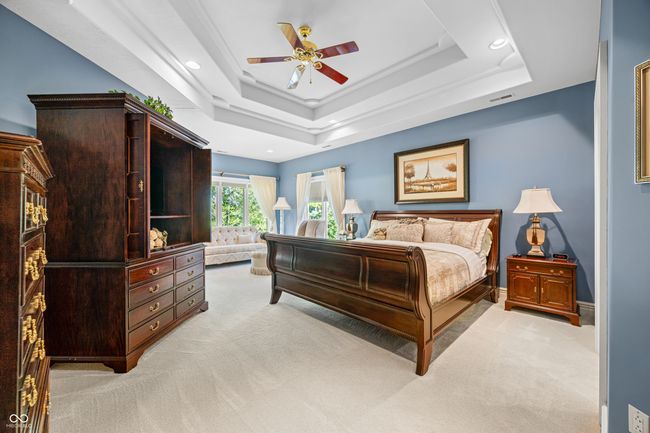 bedroom with a raised ceiling, visible vents, recessed lighting, and light carpet | Image 53
