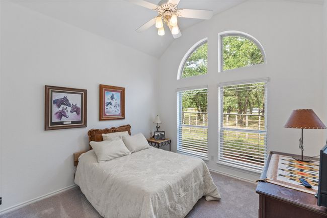 Carpeted bedroom featuring high vaulted ceiling, baseboards, and ceiling fan | Image 19