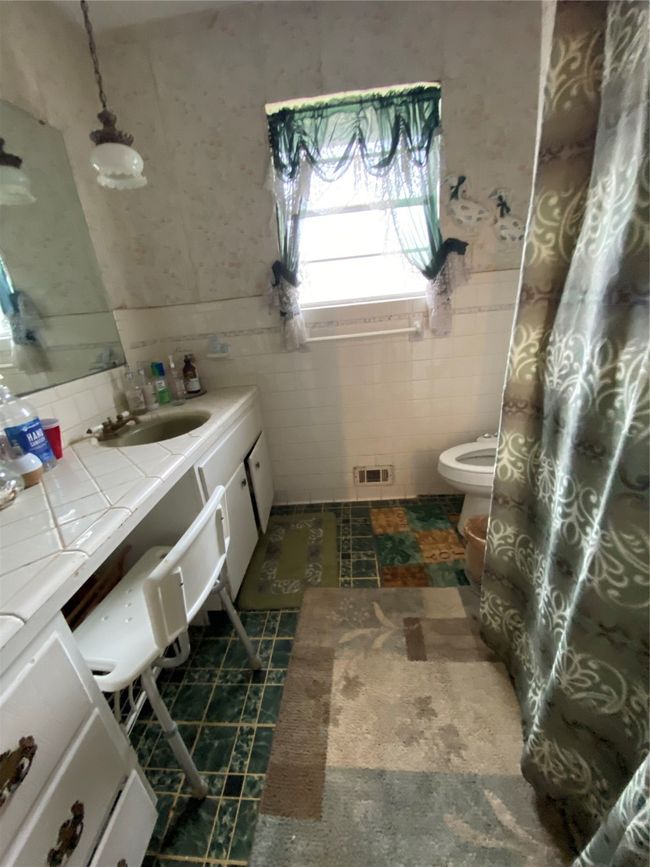 Full bathroom with tile walls, vanity, toilet, and wainscoting | Image 16