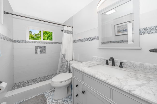 Full bathroom with toilet, vanity, tiled shower, and tile patterned floors | Image 22