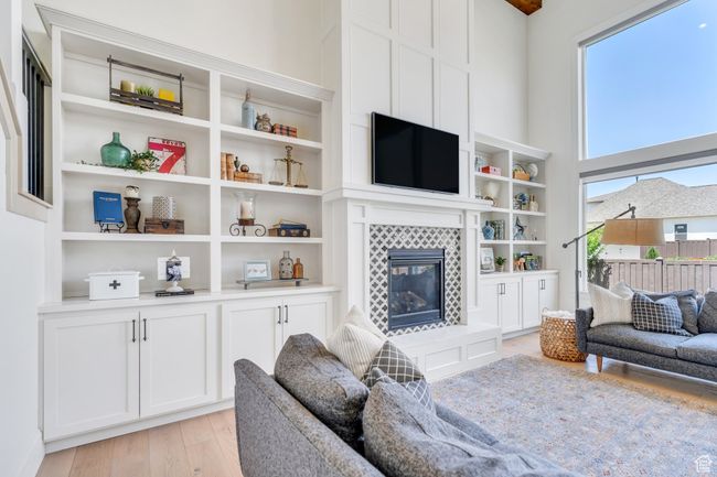 Living room with light wood-type flooring and a fireplace | Image 7